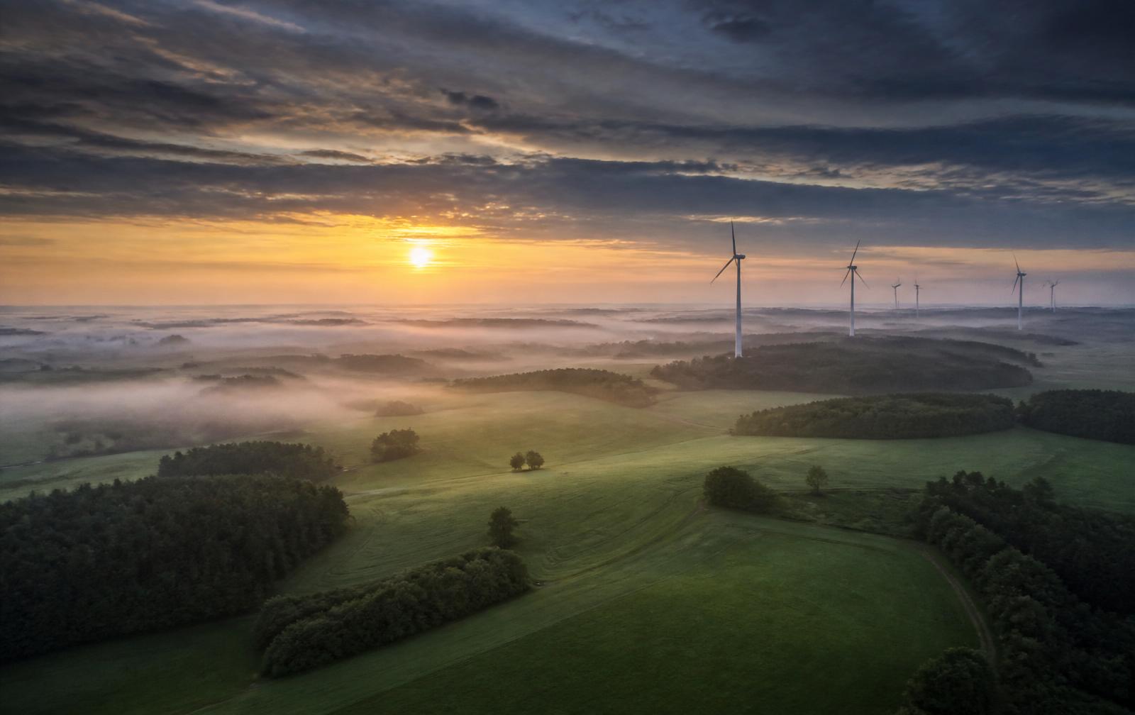Windräder in der deutschen Landschaft bei Sonnenaufgang
